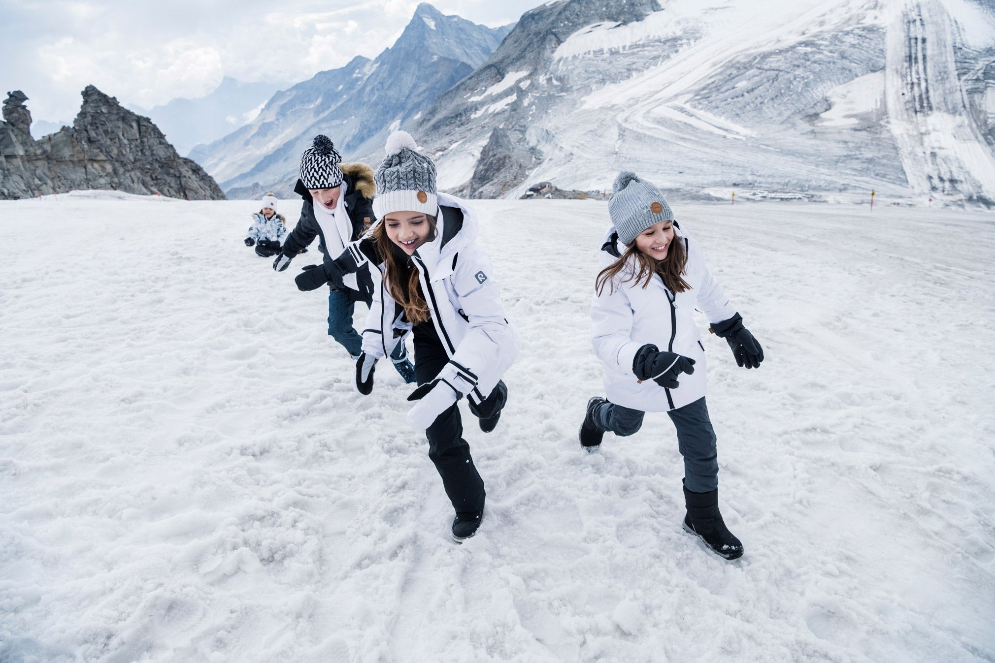 Kids on the snow in kids snow gear running on snow