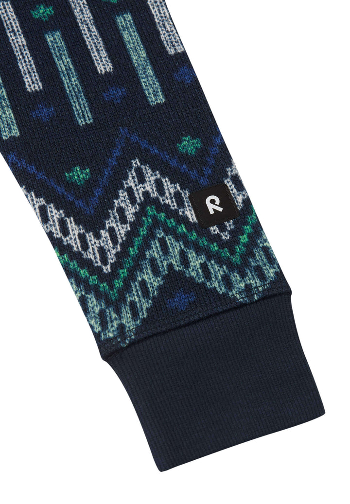 Close-up of the patterned sleeve of the Reima Myytti Fleece Overall in navy, featuring colorful geometric designs.